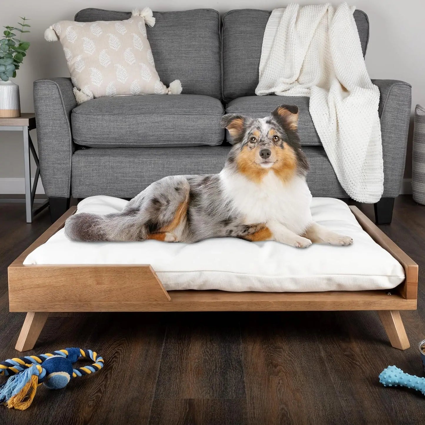 Scandinavian style elevated pet sofa bed designed for dogs, featuring a thick cushioned sleeping surface with an open front entry, sturdy wooden frame, and raised legs for supportive and comfortable resting