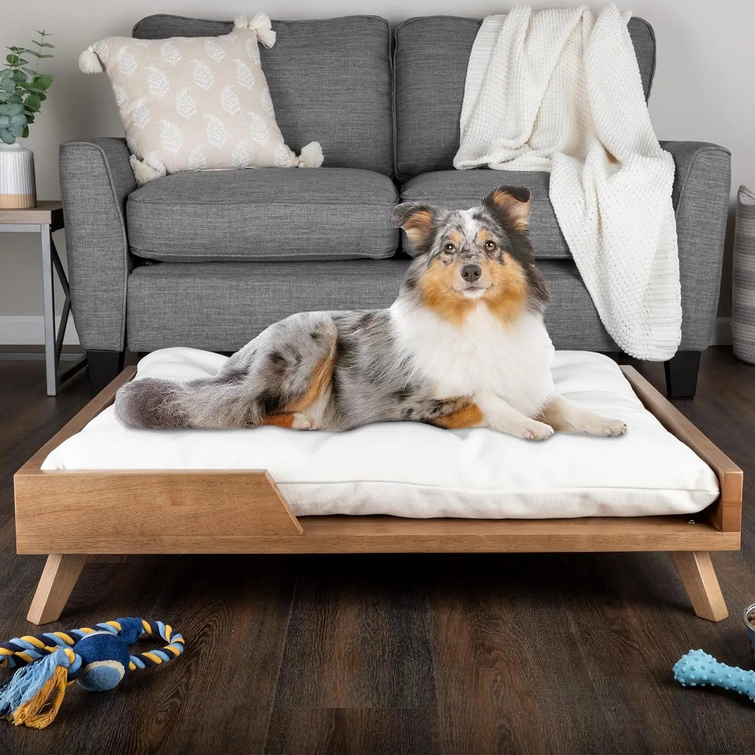 Scandinavian style elevated pet sofa bed designed for dogs, featuring a thick cushioned sleeping surface with an open front entry, sturdy wooden frame, and raised legs for supportive and comfortable resting